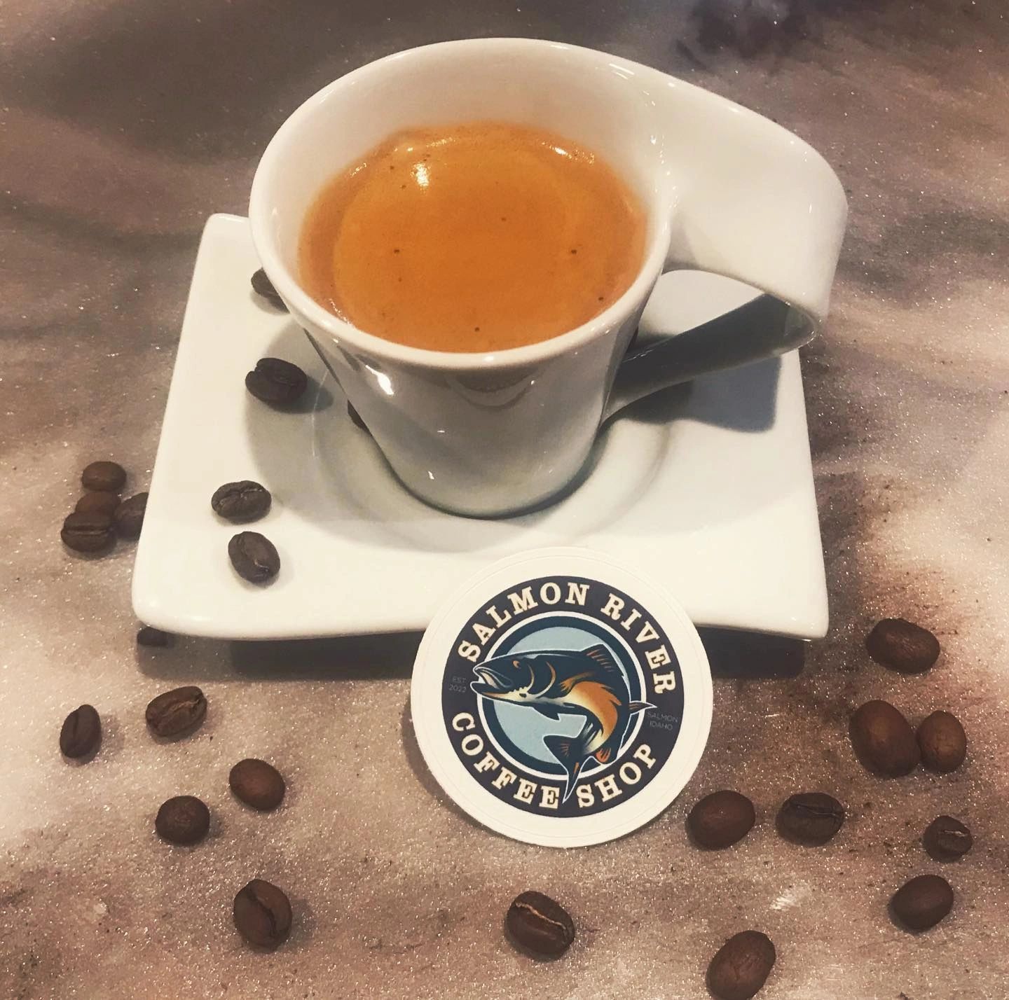Espresso cup with Salmon River Coffee Shop coaster and coffee beans